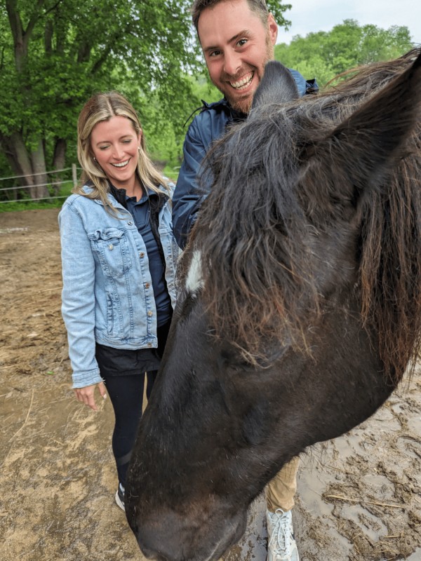 Couple visit with black horse.